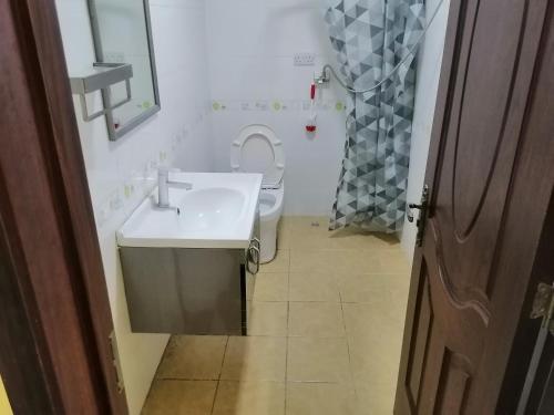 uma casa de banho com um lavatório branco e um WC. em BleVaMa Ocean View Home em Dar es Salaam