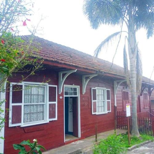 a red house with a palm tree in front of it at Pousada Maranata B&B in Paranapiacaba