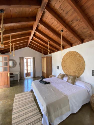 Un dormitorio con una cama grande en una habitación con techos de madera. en Casa Los Llanos en Playa de Santiago