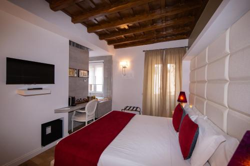 ローマにあるCorso Suite 107 Rooms Wellness & Spaのベッドと机とテレビのある寝室