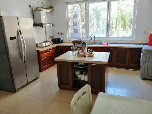 uma cozinha com um frigorífico de aço inoxidável e um lavatório em BleVaMa Ocean View Home em Dar es Salaam
