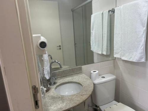 y baño con lavabo, aseo y espejo. en Apart-Hotel Setor Hoteleiro Norte com serviço diário de limpeza, en Brasilia
