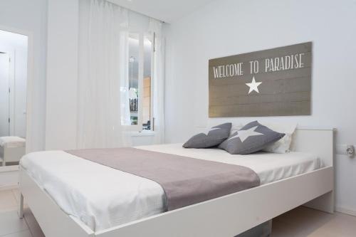 a white bedroom with a large bed in a room at Tarida in Alcudia