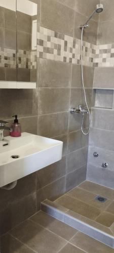 a bathroom with a shower and a sink and a shower at Vila marmelada in Leptokaria