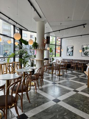 un restaurante con mesas y sillas y suelo a cuadros en 2Home Hotel Apartments en Solna