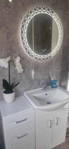 a bathroom with a white sink and a mirror at Hillend Self-Catering in Portree