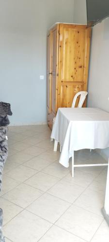 a white table and chair in a room with a door at Vila marmelada in Leptokaria