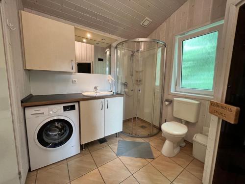 uma casa de banho com uma máquina de lavar roupa e um WC em Ferienhaus Freibeuterweg 13 - b51130 em Lübeck