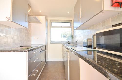 une cuisine avec des comptoirs en marbre et une fenêtre dans l'établissement 35 Sandown Bay Holiday Park, à Sandown