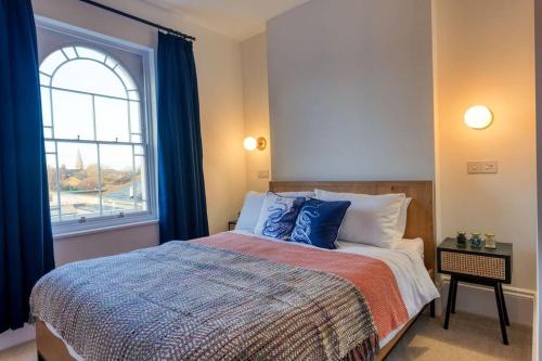 1 dormitorio con 1 cama grande y ventana en The Lookout - Stylish penthouse with sea views en Kent