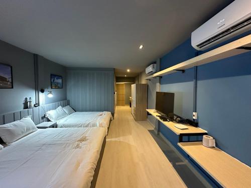 a hotel room with two beds and a television at Phuket vibe, City House, 7 mins to BTS, City center, Private room in Sathon, Private bathroom, Bangkok, Thailand in Bangkok
