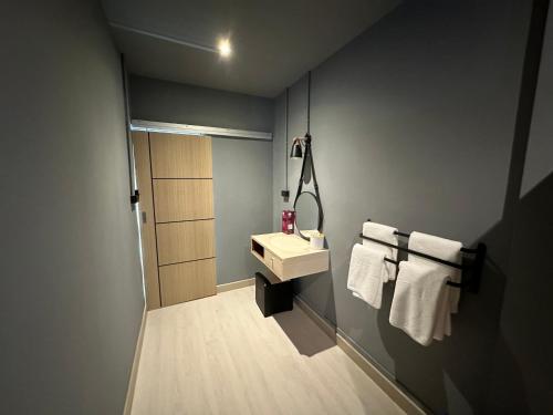 a bathroom with a sink and white towels at Phuket vibe, City House, 7 mins to BTS, City center, Private room in Sathon, Private bathroom, Bangkok, Thailand in Bangkok