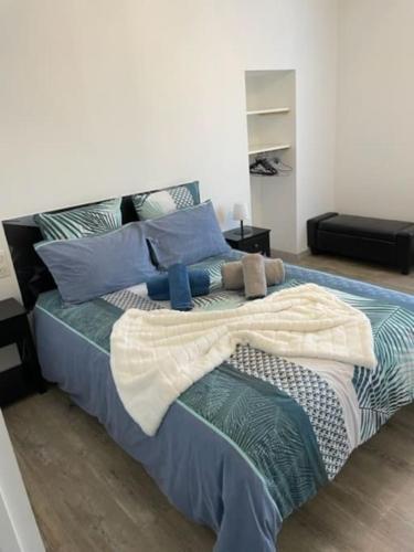 une chambre avec un grand lit avec des oreillers bleus dans l'établissement La Madone, à Cadillac-en-Fronsadais