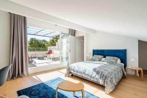 een slaapkamer met een blauw bed en een balkon bij Le petit clos St Devote par Dodo à Cassis in Cassis