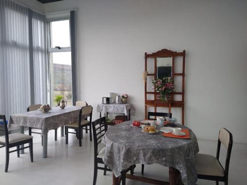 una sala da pranzo con tavoli, sedie e uno specchio di Alto Las Loicas B&B a Esquel