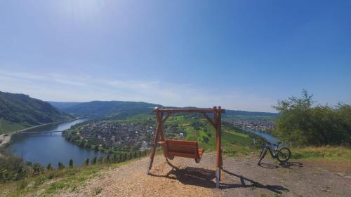 a bench on a hill next to a river at Paradies Camp in Kröv
