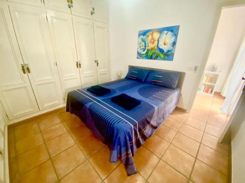 ein Schlafzimmer mit einem blauen Bett in einem Zimmer mit weißen Schränken in der Unterkunft Precioso apartamento silencioso y céntrico in Fuengirola