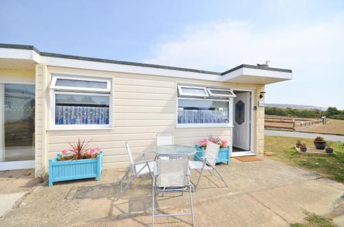 a table and chairs in front of a house at 36 Sandown Bay Holiday Centre in Brading