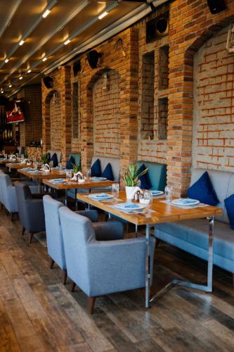 a dining room with wooden tables and blue chairs at Millennium Kurdistan Hotel & Spa in As Sulaymānīyah