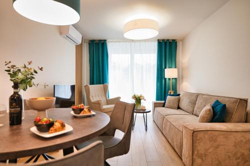a living room with a couch and a table at Laguna Beskidów Resort - Apartament A83 in Zarzecze