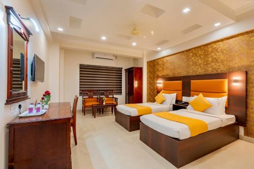 a hotel room with two beds and a dining room at Daan Orchid Residency in Kottayam