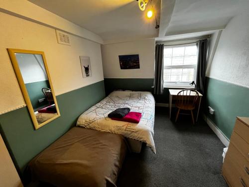 a small bedroom with two beds and a mirror at Keysan House 5 in London