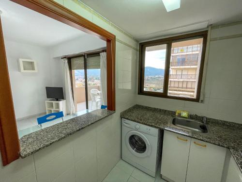 a bathroom with a washing machine and a window at Apartamentos Benicassim 3000 in Benicàssim