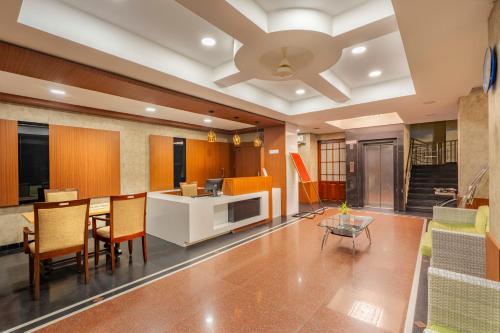 a living room with a table and chairs and a ceiling at Daan Orchid Residency in Kottayam