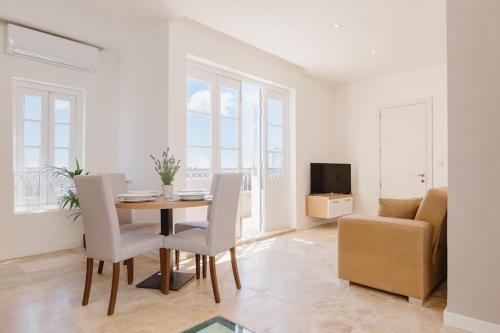 uma sala de estar com uma mesa e cadeiras e um sofá em Rare Seaview Valletta Penthouse em Valletta