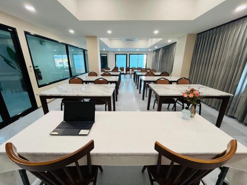 a cafeteria with tables and chairs with a laptop on them at USABAI Riverside Boutique Hotel in Chanthaburi