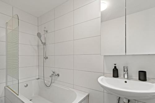 y baño blanco con lavabo y ducha. en Stilvolles Zuhause mit Terrasse, en Bruck an der Mur