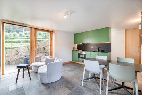a kitchen with green cabinets and a table and chairs at VIVA Douro Countryside Lodge in Cinfães