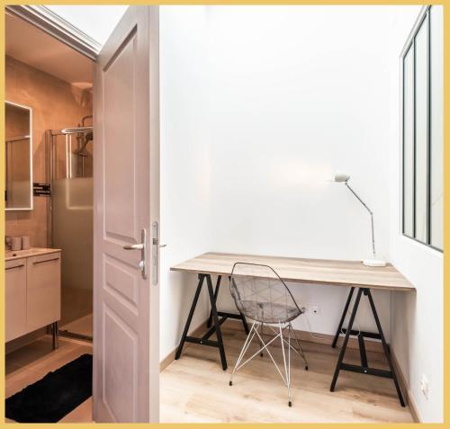 um quarto com uma secretária e uma cadeira numa cozinha em Appart T3 Luxe Douvaine em Douvaine