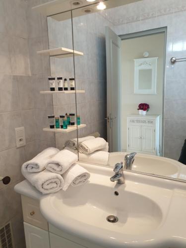 une salle de bain blanche avec un lavabo et un miroir dans l'établissement Cannes Satellite, à Cannes