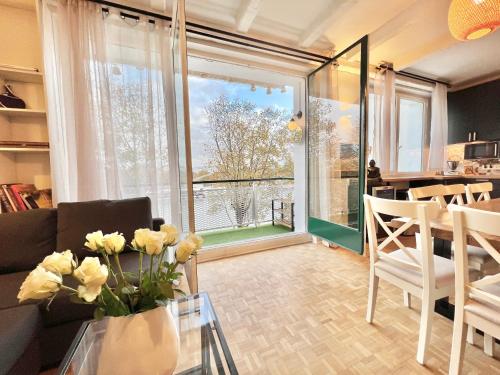 un salon avec un canapé et une table avec des fleurs dans l'établissement Apartment ParisNicoStay - Cosy 4 bedrooms flat Seine river, à Paris