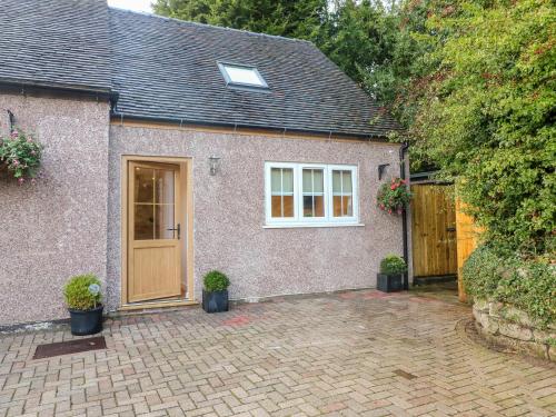 a brick house with a door and potted plants at Farley Cottage II in Alton