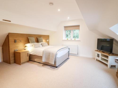 a bedroom with a bed and a flat screen tv at Farley Cottage II in Alton