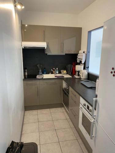 une petite cuisine avec un évier et une cuisinière dans l'établissement T3 pont romain Amelie les bains, à Amélie-les-Bains-Palalda