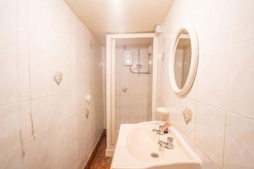 a white bathroom with a sink and a mirror at Rochdale Train STN, Large House in Rochdale