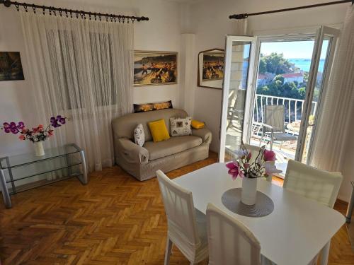 a living room with a table and a couch at Indy's Sunny Apartment in Dubrovnik