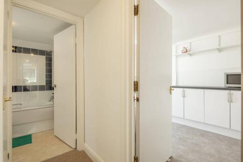 Habitación con armarios blancos y cocina con puerta. en Spacious 3 Bedroom Flat In HEART Of City Centre en Cambridge