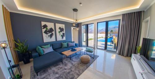 a living room with a blue couch and a tv at Holiday Home Noa in Mostar