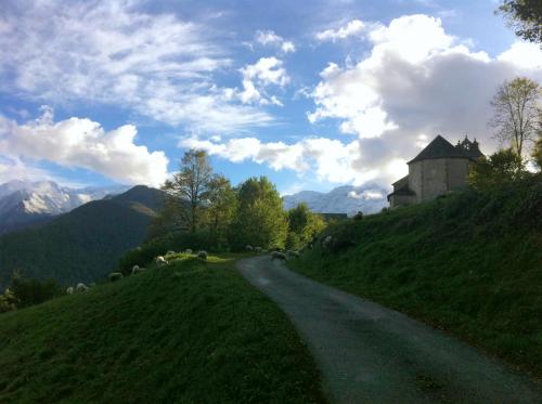 un chemin de terre menant à un bâtiment sur une colline dans l'établissement Au détour Du Larrech, à Castillon-en-Couserans