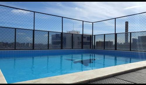 uma piscina com uma cerca num edifício em Apartamento 2 quartos na Jatiúca em Maceió