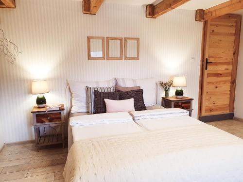 sypialnia z dużym białym łóżkiem z 2 stolikami nocnymi w obiekcie Apartament Czar-nów w mieście Kamienna Góra