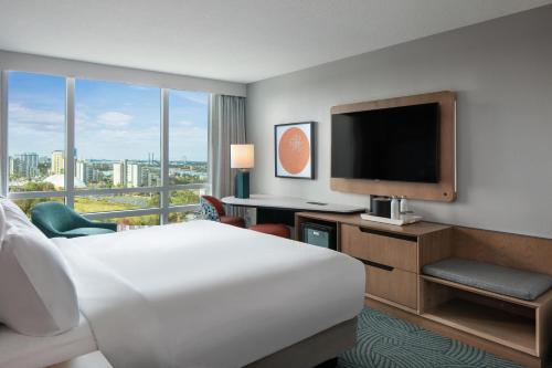 a hotel room with a bed and a flat screen tv at Hotel Landy Orlando Universal Blvd, a Tribute Portfolio Hotel in Orlando