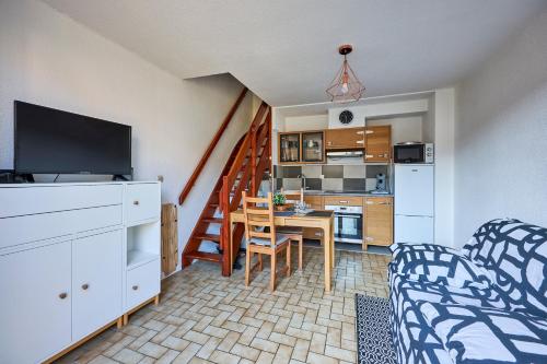 un salon avec une table de salle à manger et une cuisine dans l'établissement La Villa Fleurie - Appt à 50m de la plage, à Courseulles-sur-Mer