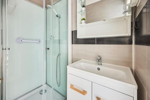 une salle de bain avec un lavabo et une douche dans l'établissement La Villa Fleurie - Appt à 50m de la plage, à Courseulles-sur-Mer