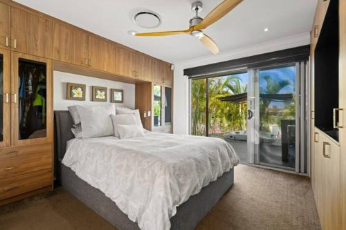 a bedroom with a large bed and a large window at Luxurious home with pool and Water views in Gold Coast