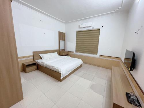 1 dormitorio con 1 cama y TV en Phương Linh Hostel en Qua Phố